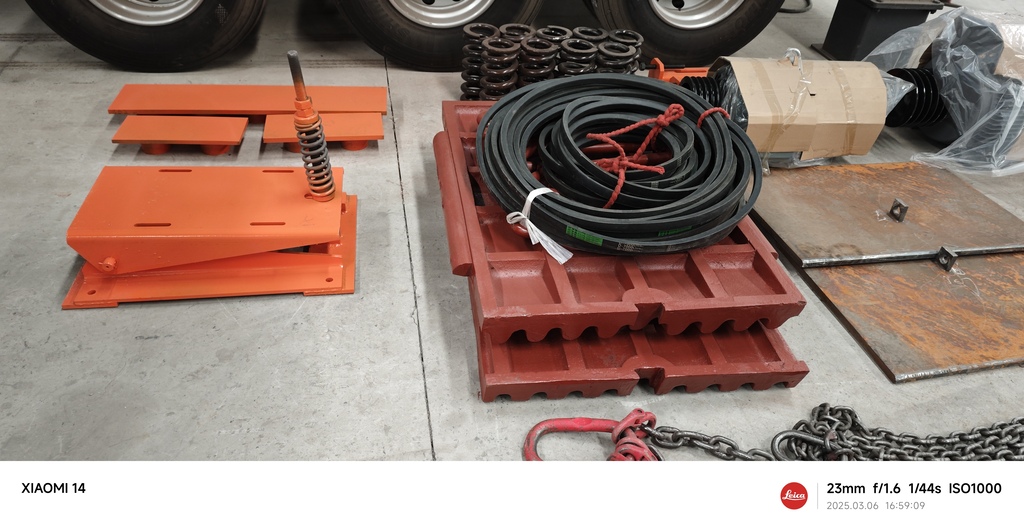 Wear part jaw crusher komponen feeder dan V-belt di-staging untuk pengiriman